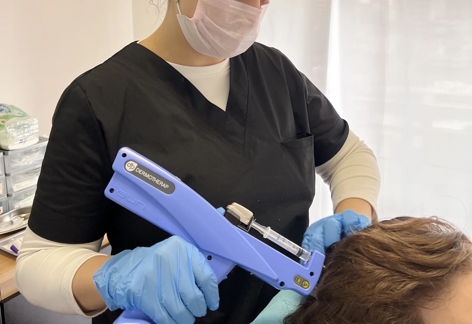 Profesional de JF durante una sesión de mesoterapia capilar.